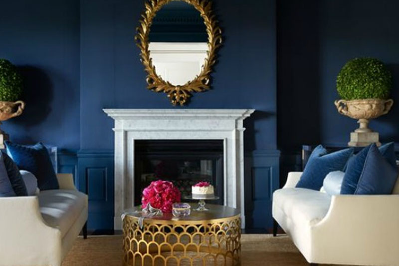 Navy blue walls contrast with furniture