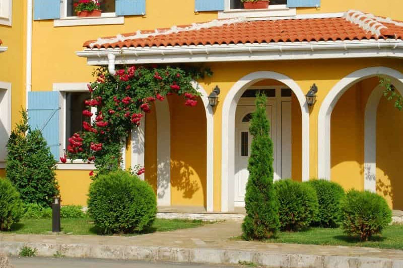 Pristine white front door in yellow house