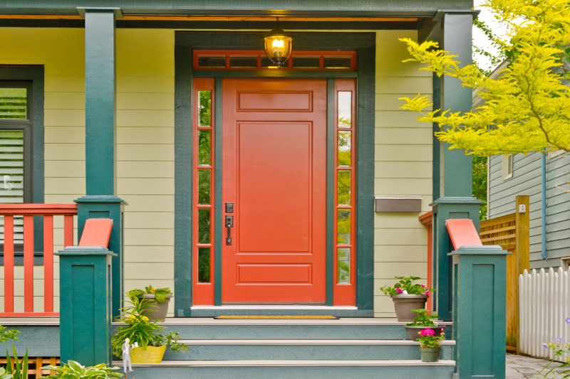 Rusty red frond door with yellow house